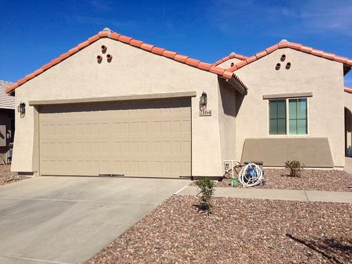 Tan garage door on a stucco home before painting