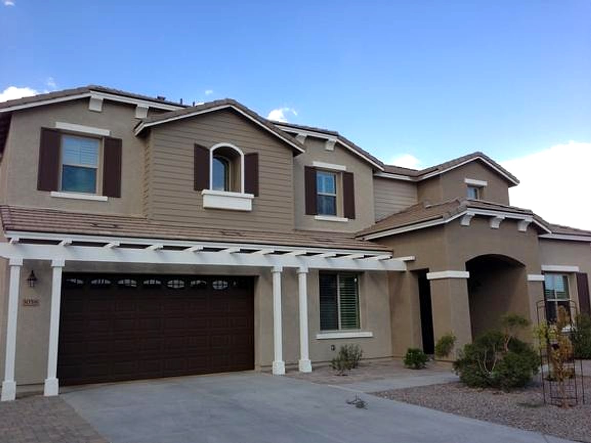 The same house after painting, with a white pergola